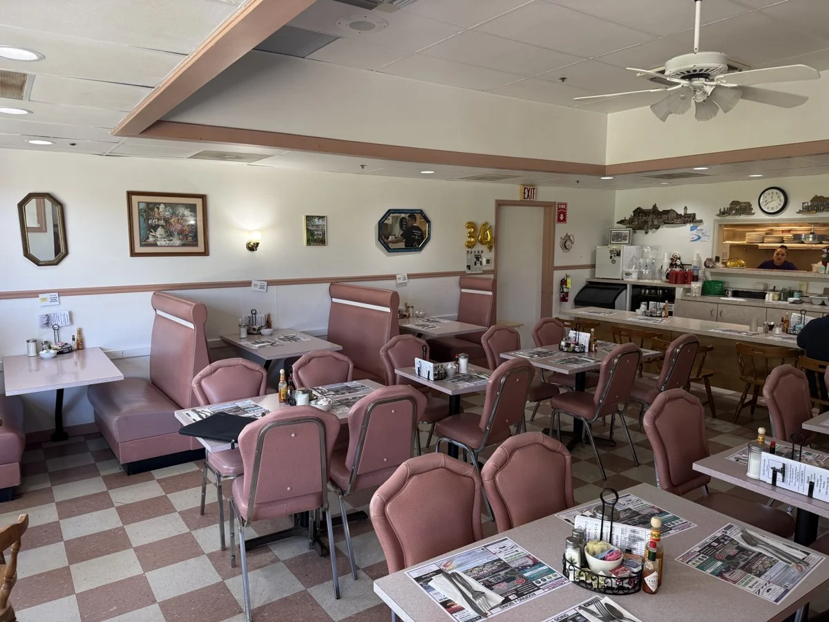 Pink booths and checkered floor in the dining room.
